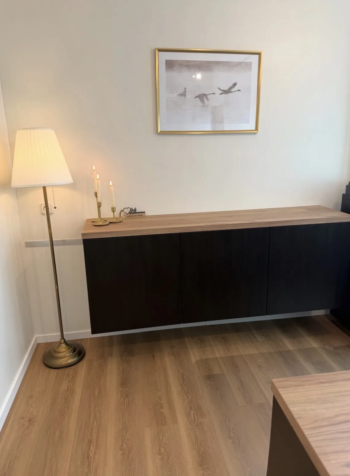 Sideboard mit brennenden Kerzen und Bild im Empfangsbereich des Bestattungshauses Prange