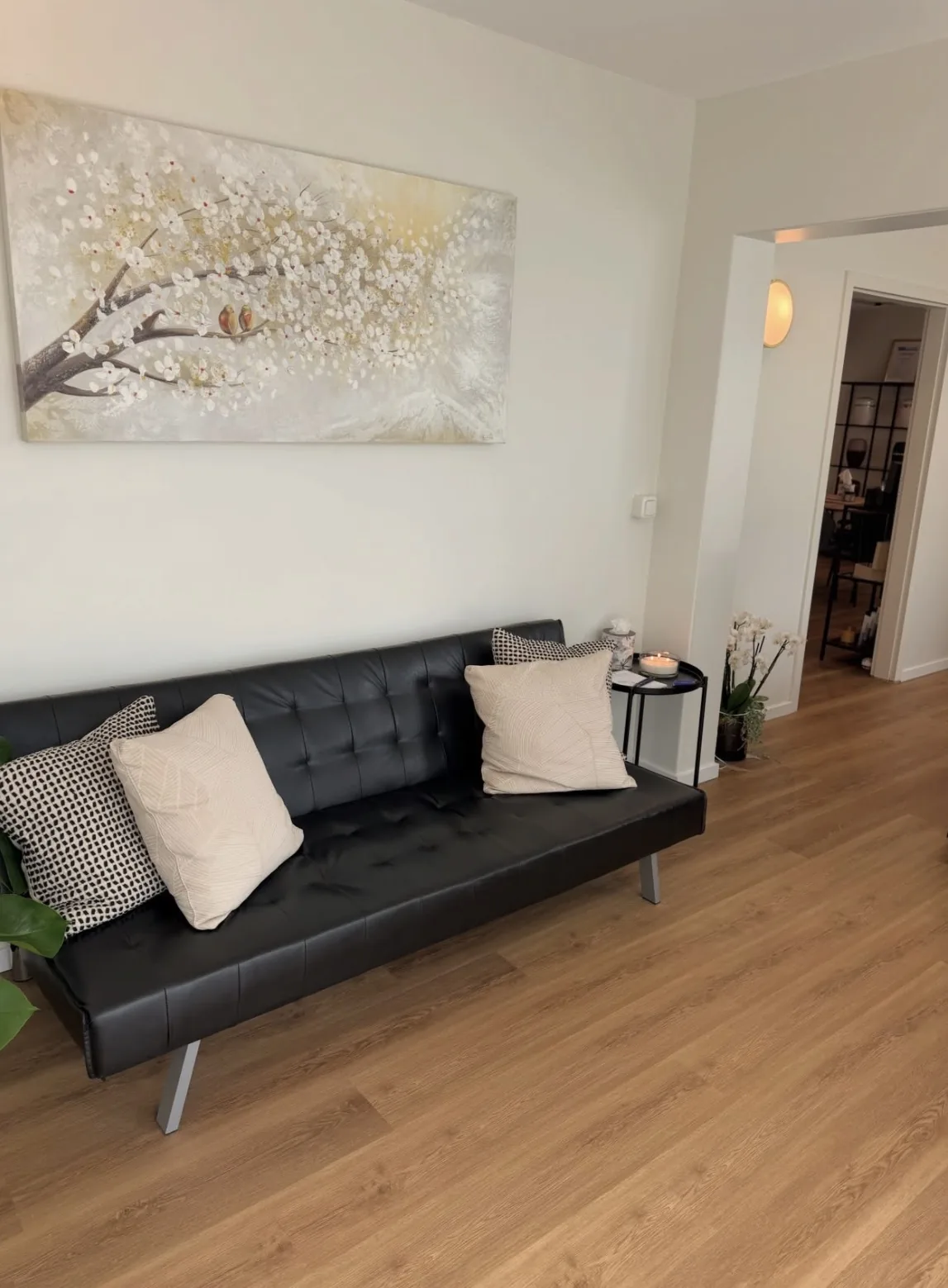 Empfangsbereich im Bestattungshaus Prange in Lüneburg mit Sofa, Kerze und Orchidee